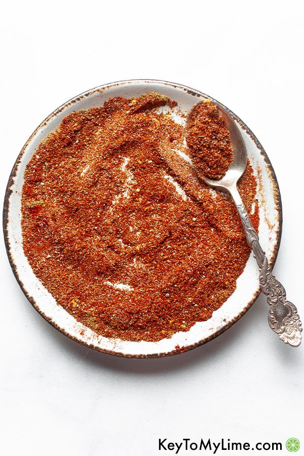 Taco seasoning mixed together on a light plate with an ornate silver spoon.