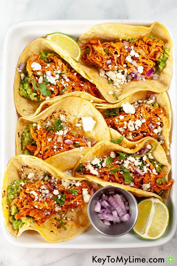 8 chicken tinga tacos in a white platter.