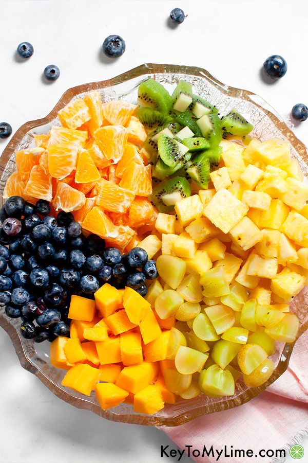 The ingredients for tropical fruit salad places separately in a large glass bowl.