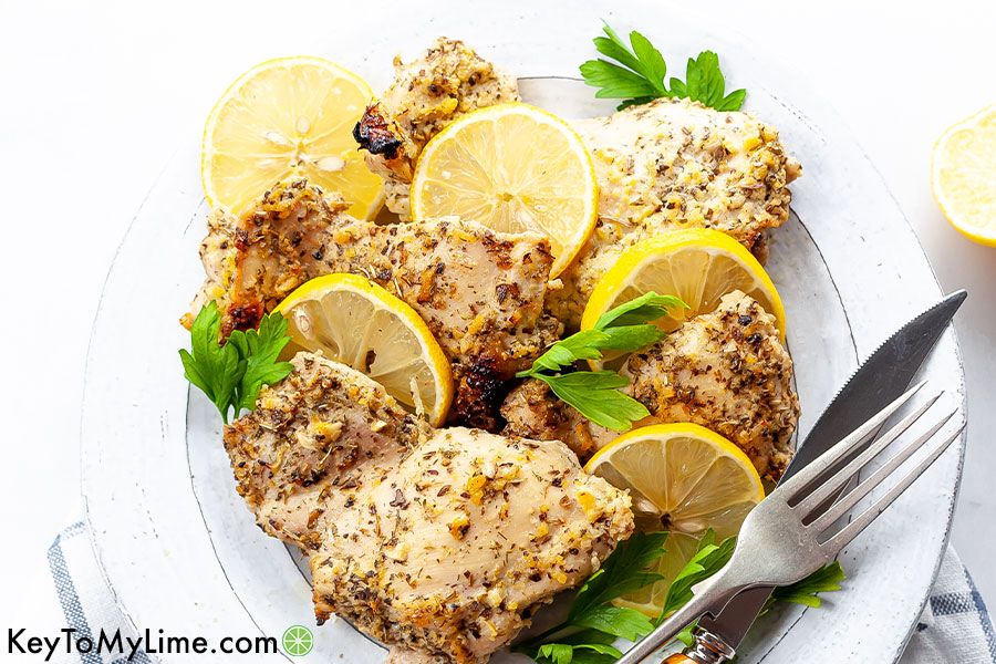 Greek chicken thighs with slices of lemon.