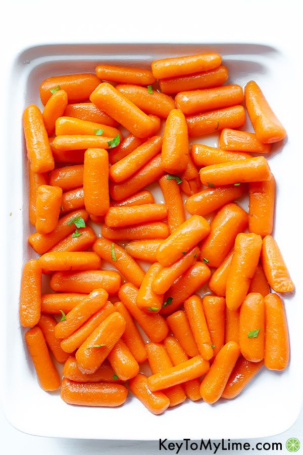 Honey roasted carrots in a white baking dish.