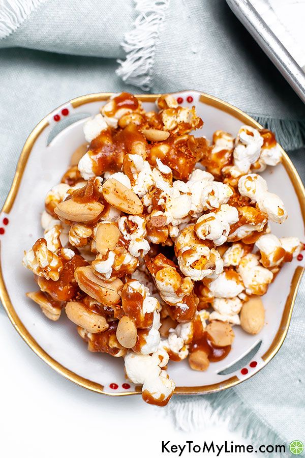 Spicy caramel popcorn in a small white and gold rimmed bowl.