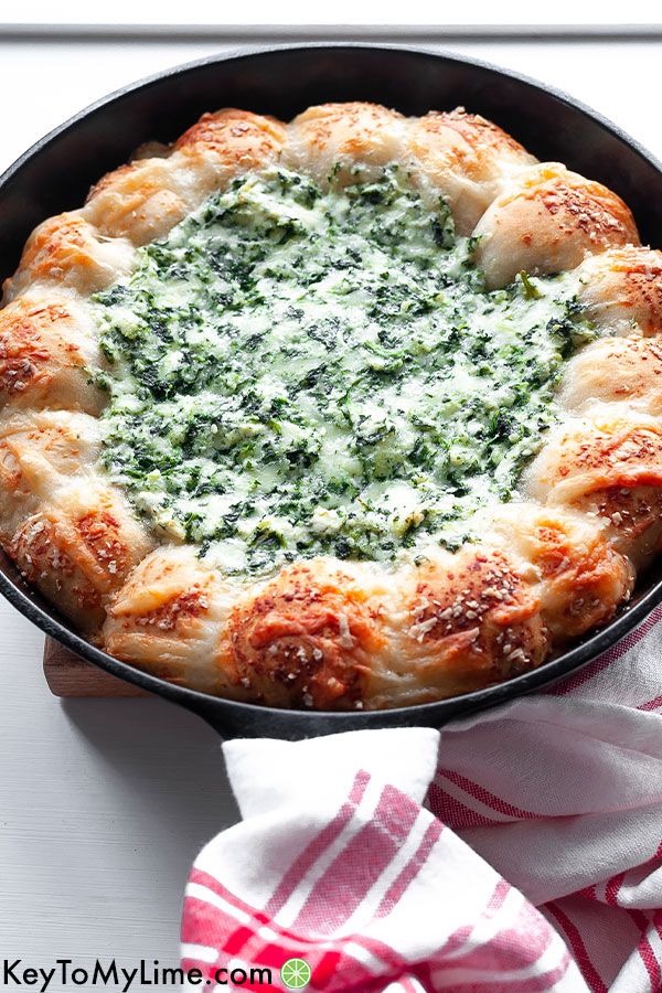 An angled photo of biscuit wreath dip showing the light glistening off of the spinach dip.