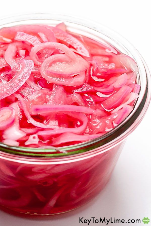 A close up image of quick pickled red onions.