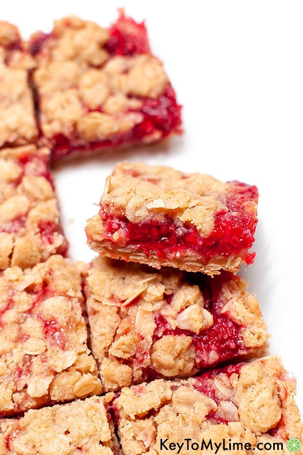 One raspberry crumble bar resting on another raspberry bar.