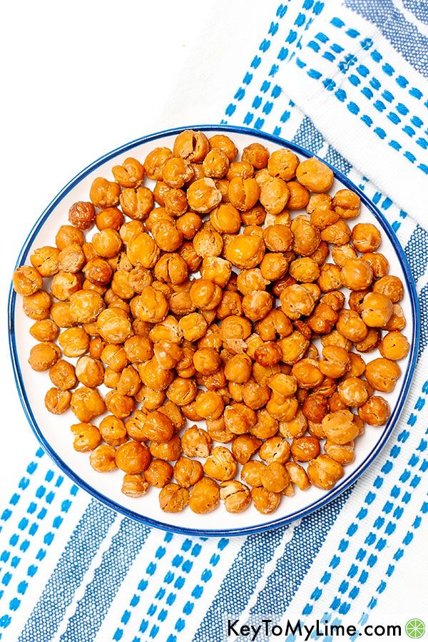 Plain roasted chickpeas on a white plate with a blue rim.