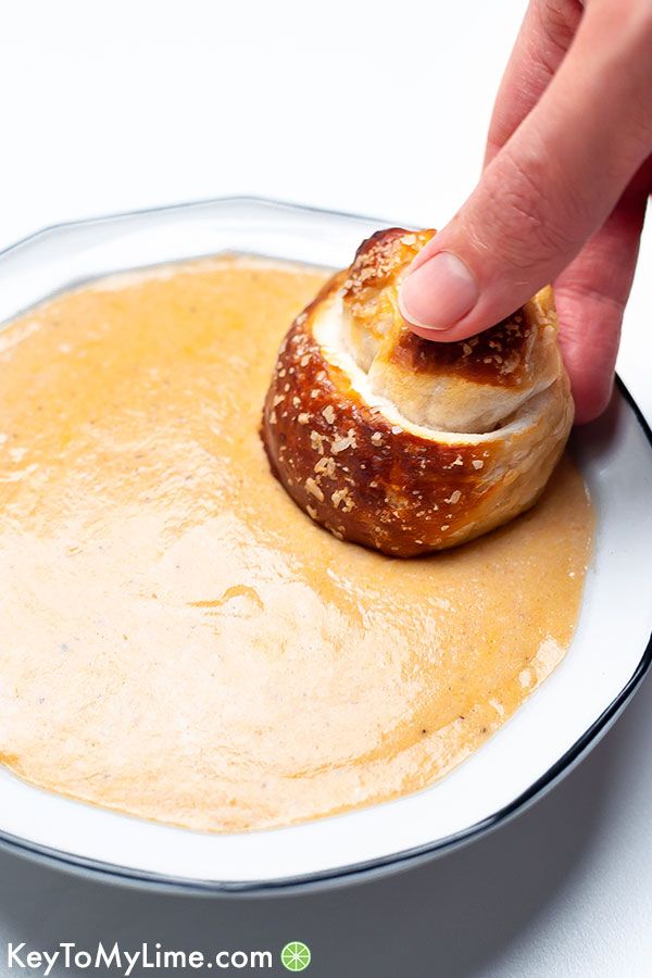 Soft pretzel dipped in cheese dip.