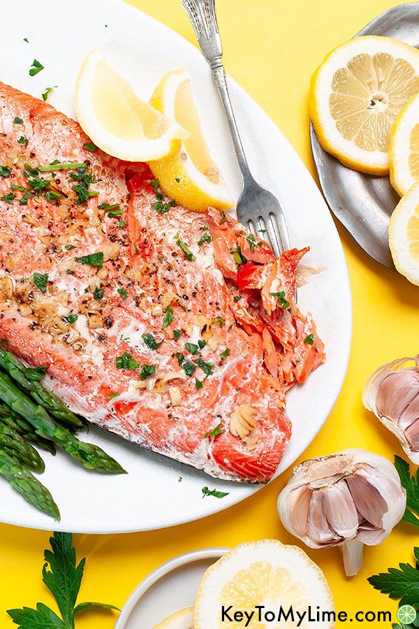 A garlic butter salmon filet on a yellow background.