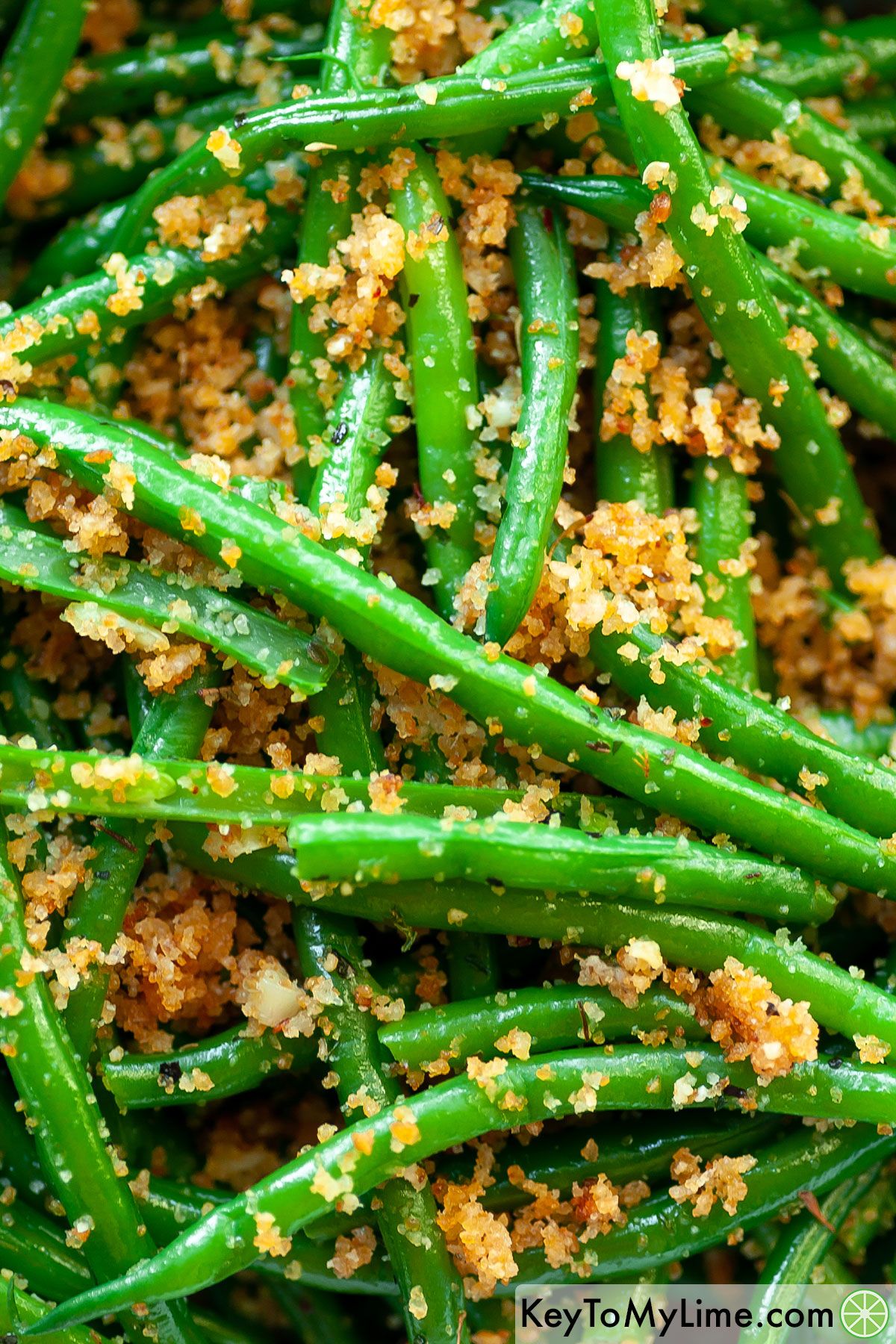 A close up image of Italian green beans coated in seasoned bread crumbs.