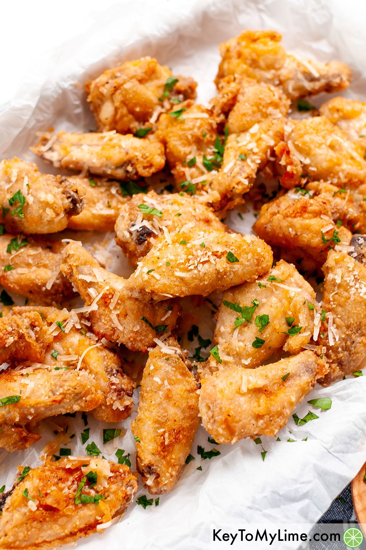 A platter of garlic parmesan wings topped with parsley.