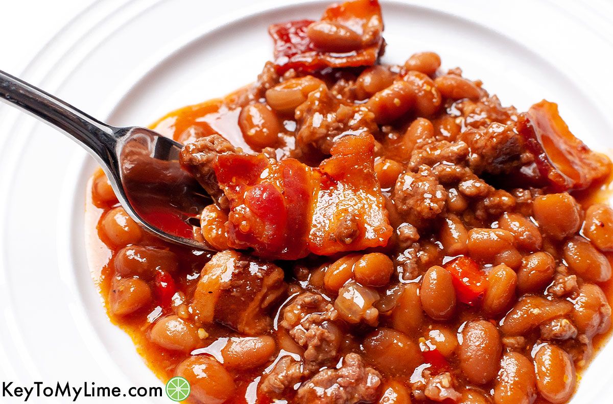 A fork taking a bite of Southern-style baked beans.
