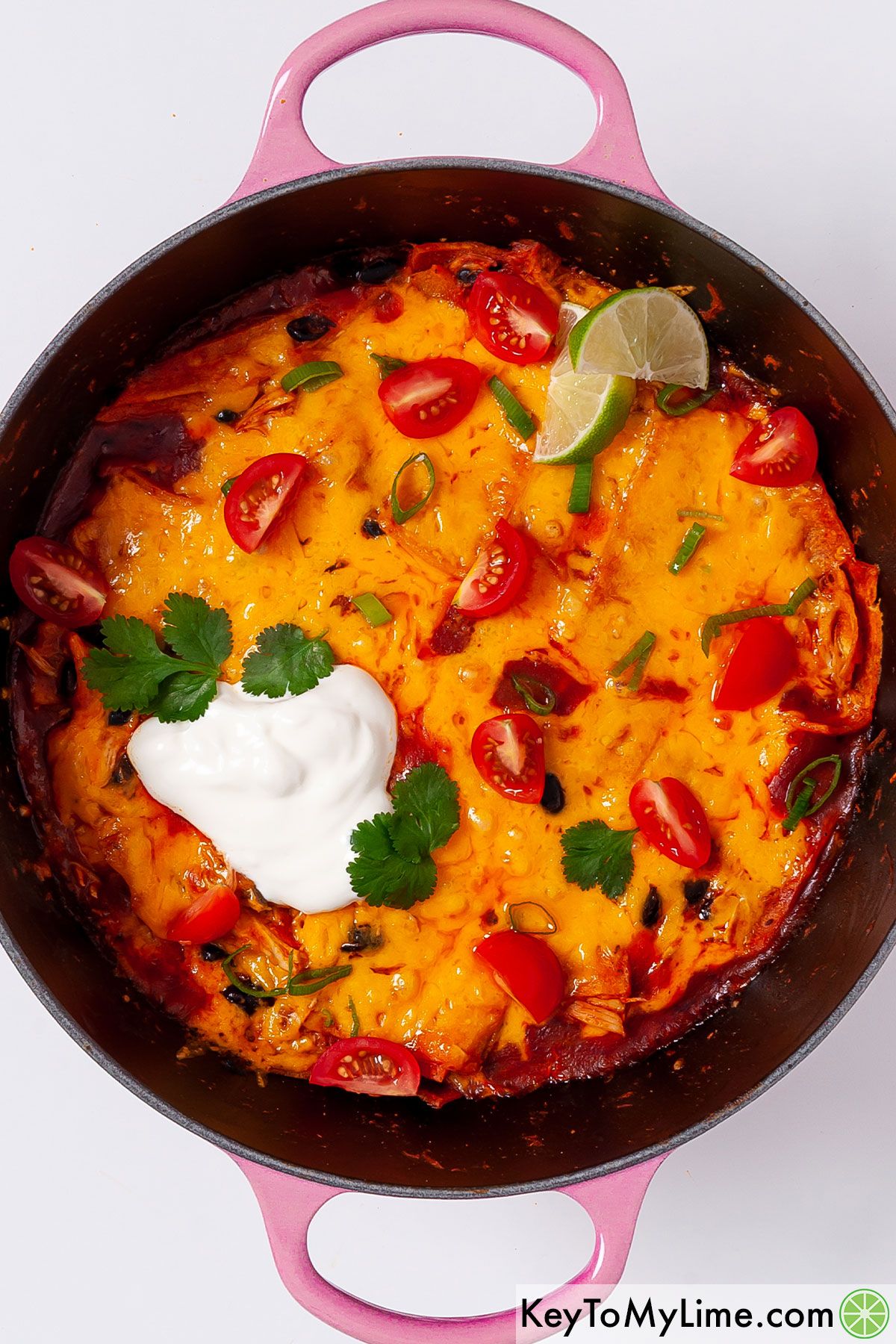 Chicken enchilada skillet garnished with fresh toppings.