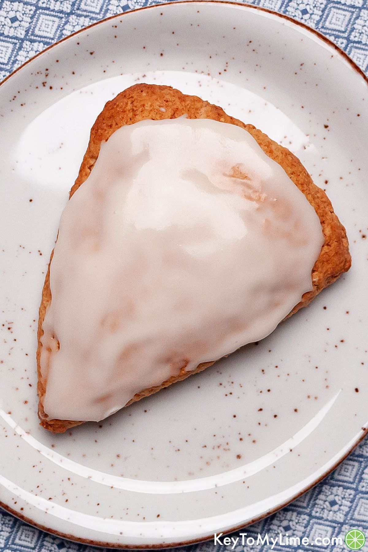 An overhead image of a vanilla glazed Bisquick scone on a plate.