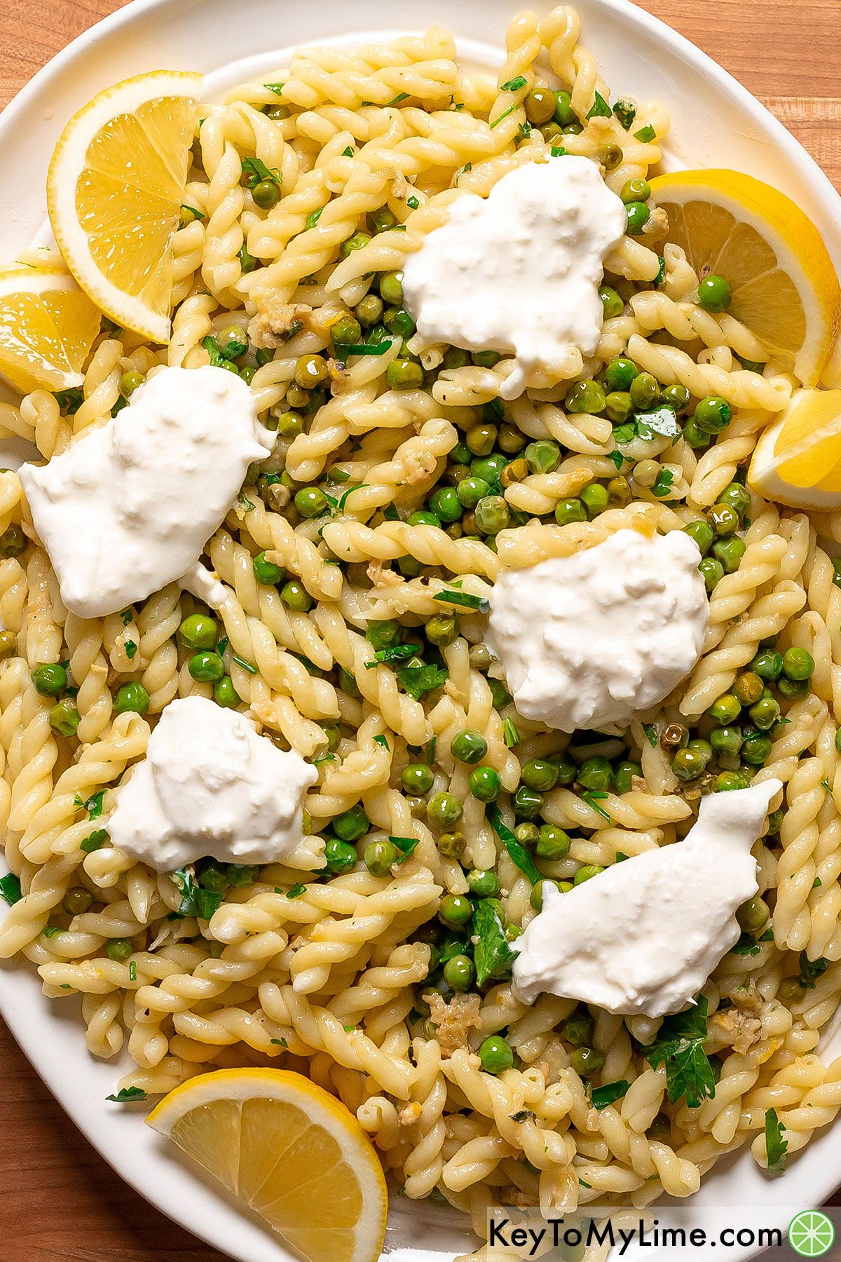 A large white platter of Spring Pea Pasta with Burrata.