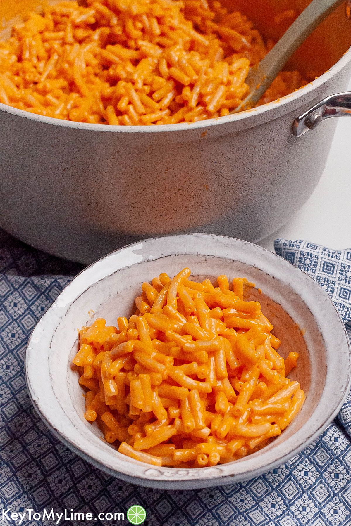 A bowl of the best Kraft mac and cheese, next to a pot of mac and cheese.