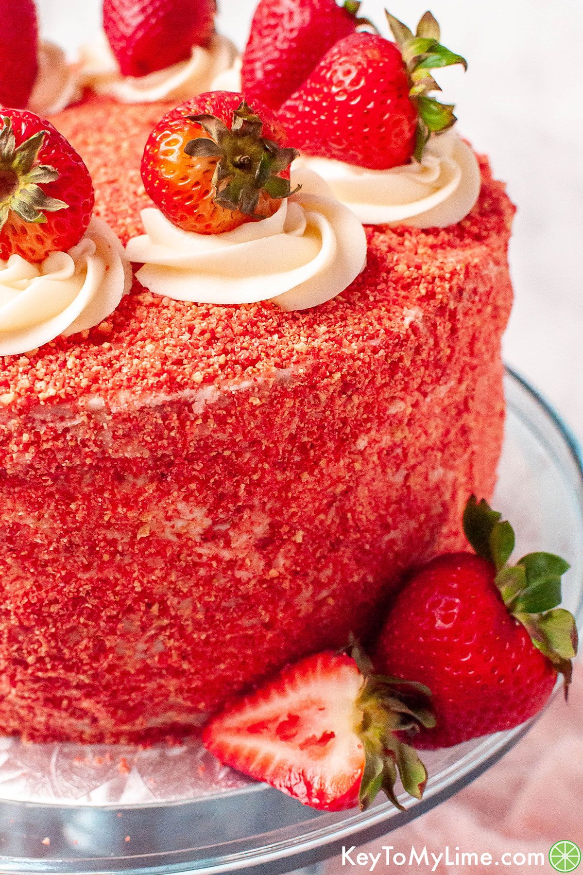 A close up image of a cake decorated with strawberry crunch topping to show the texture.