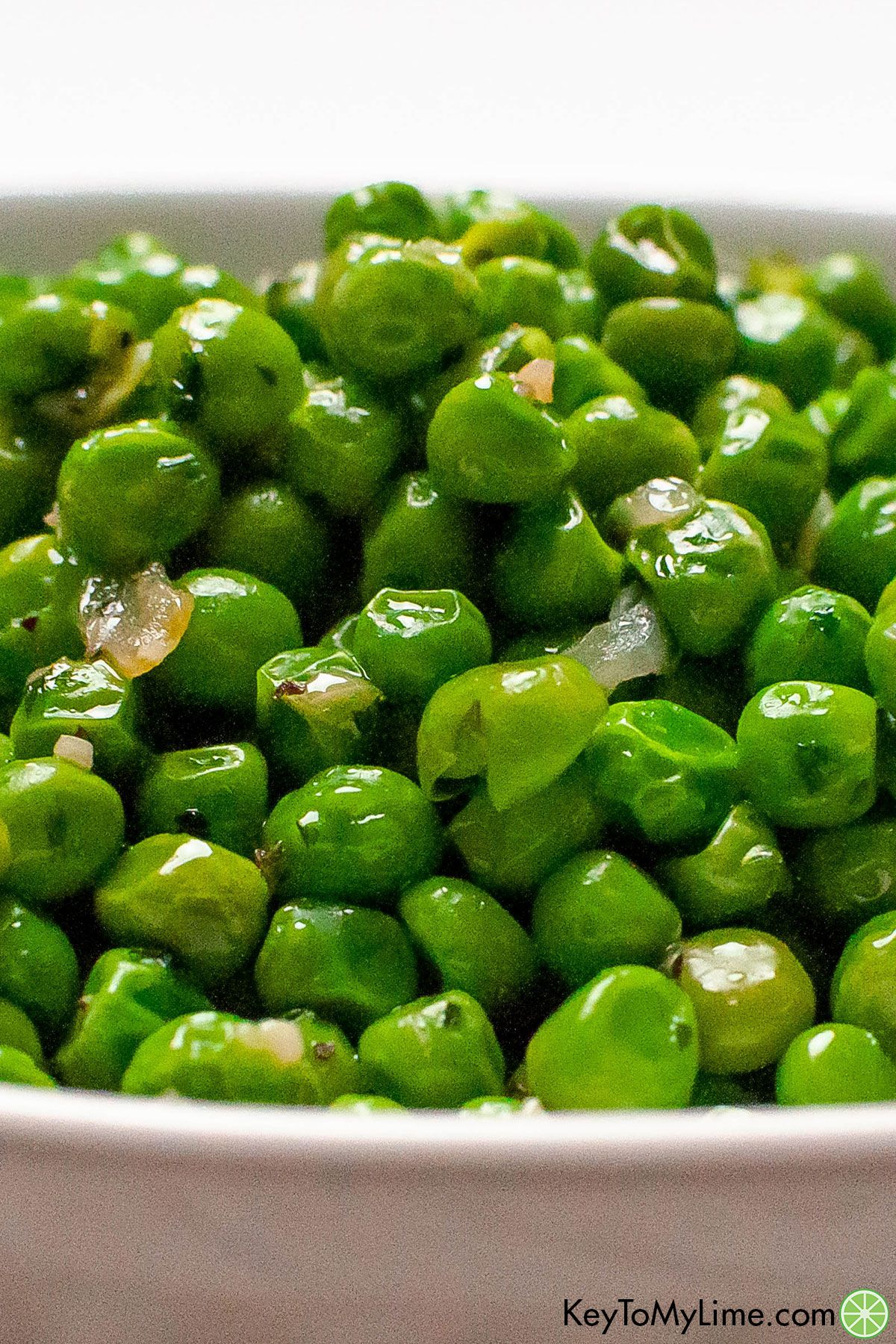 A close up image of perfectly cooked frozen peas to make the best buttery peas.