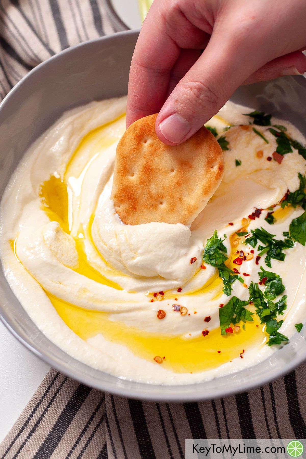Dipping toasted pita into whipped feta dip.