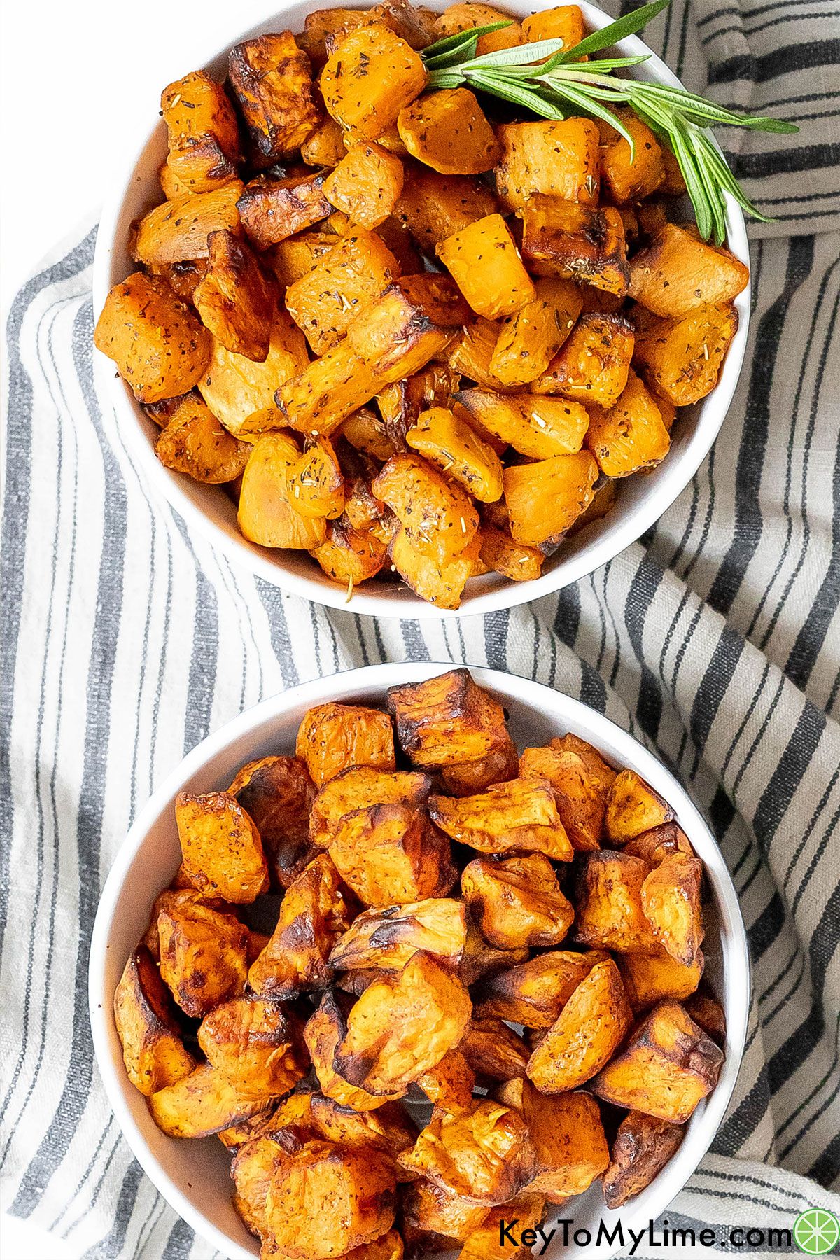 A bowl of savory sweet potato cubes next to a bowl of sweet air fryer s