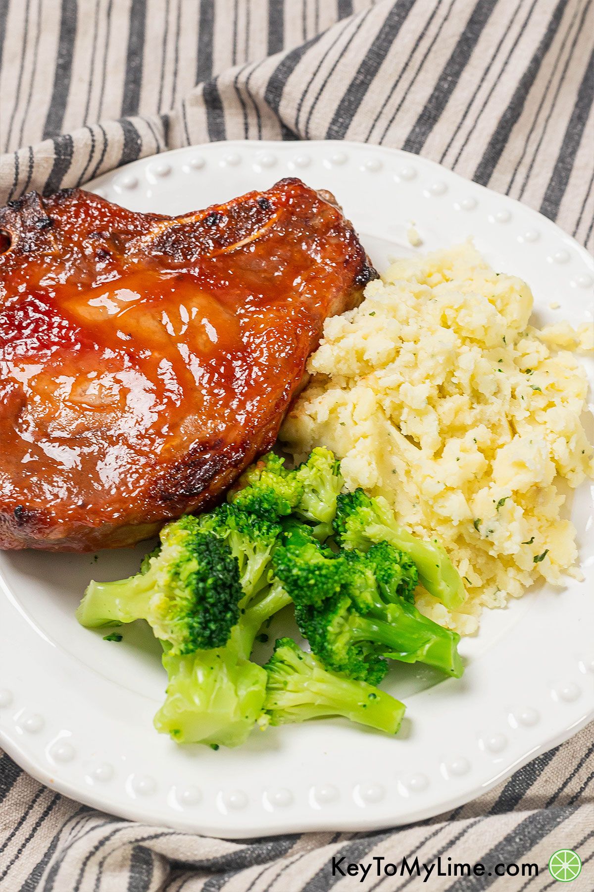 An image of plated pork chops with broccoli and potatoes.