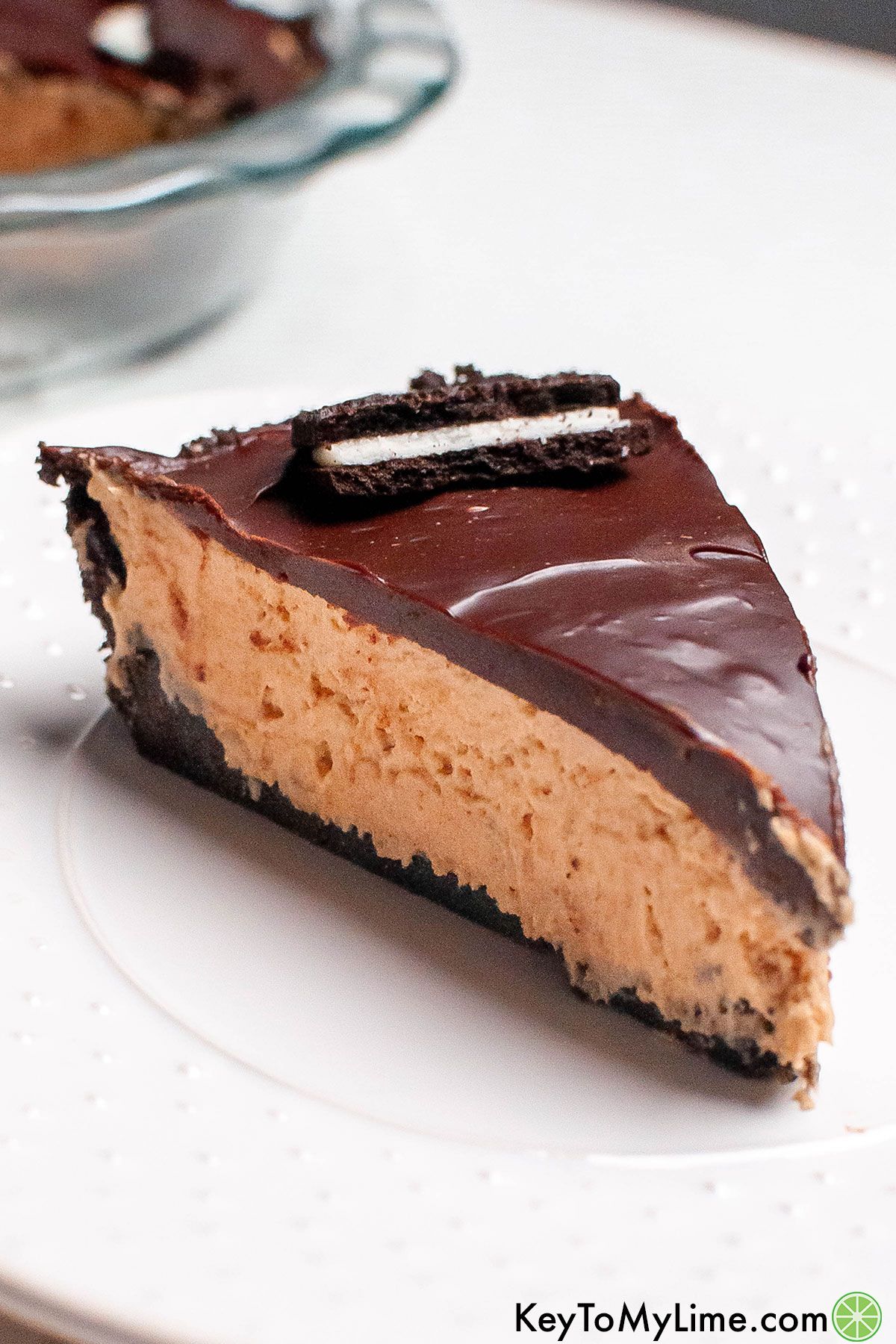 A slice of no bake chocolate peanut butter pie garnished with an oreo.