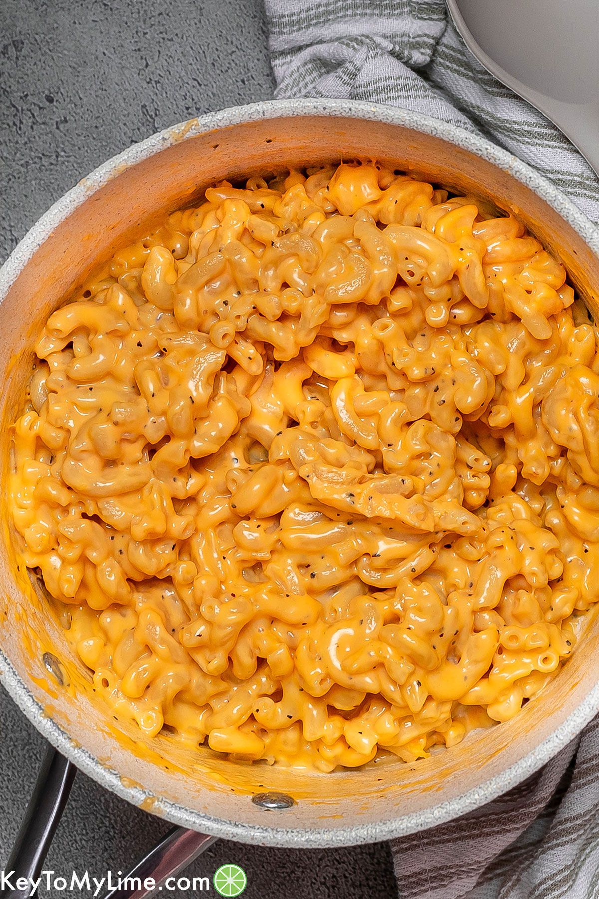 An overhead image of a large pot filled with cooked cheesy mac and cheese.