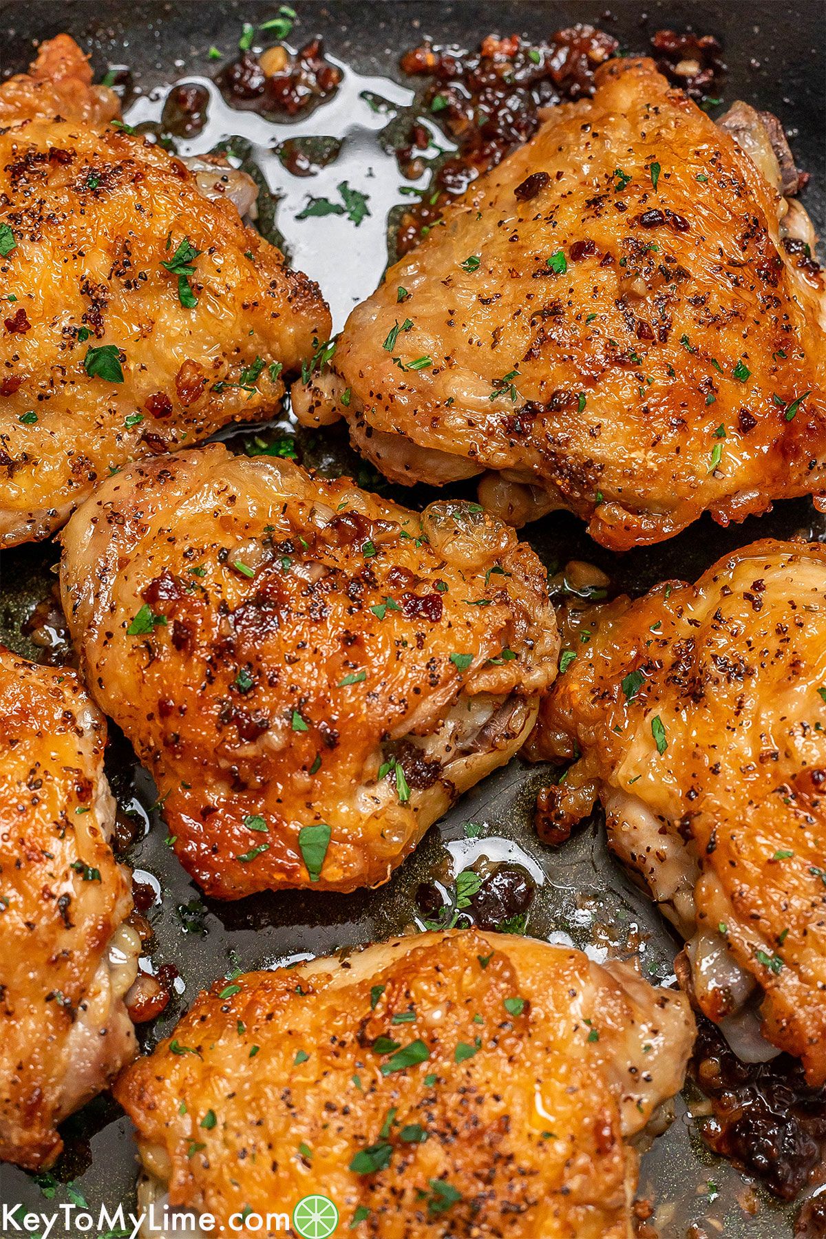 A zoomed in image showing the texture of the crispy skin on the cooked chicken thighs.