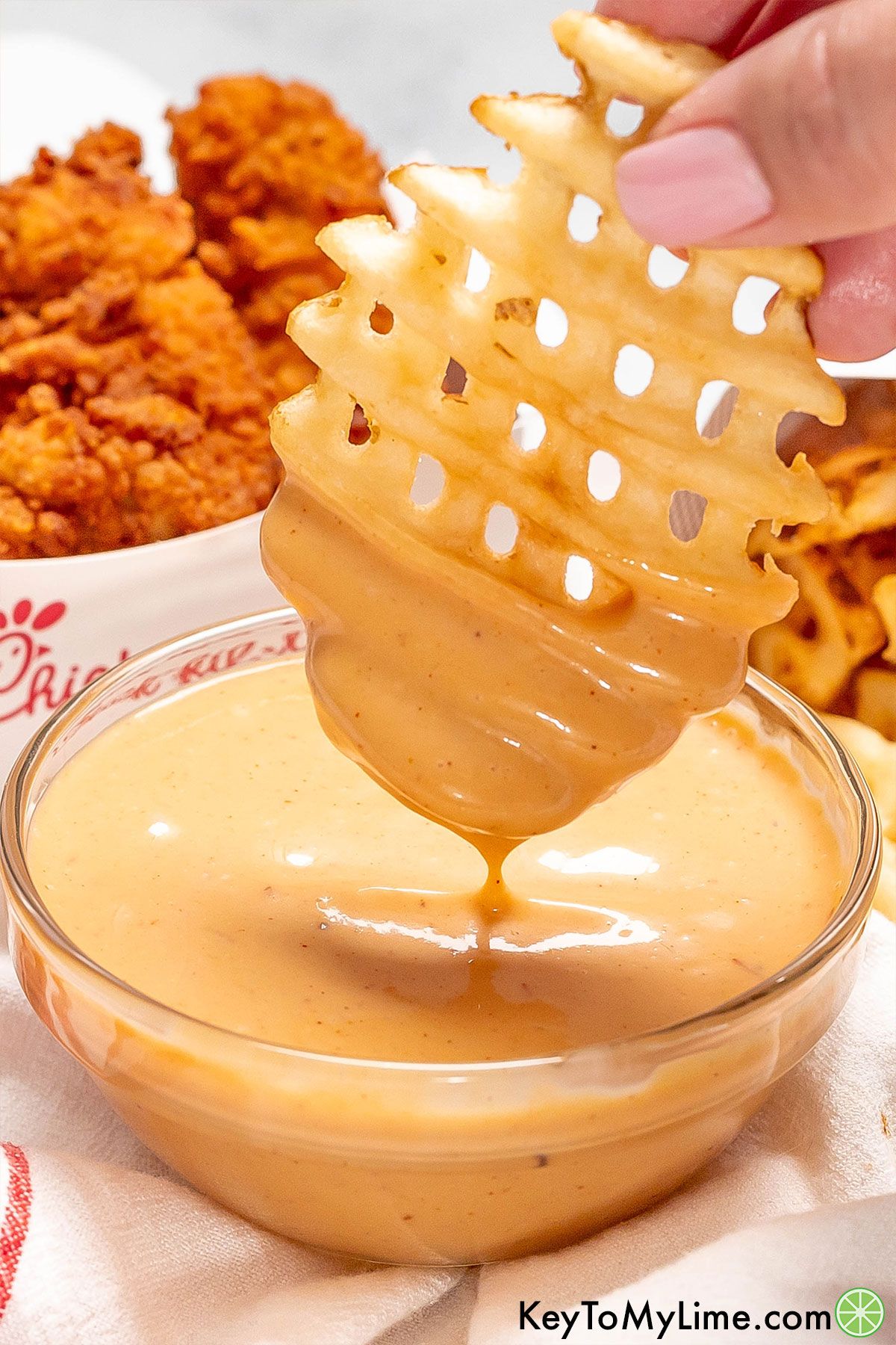 Homemade Chick Fil A sauce dripping off of a waffle fry.