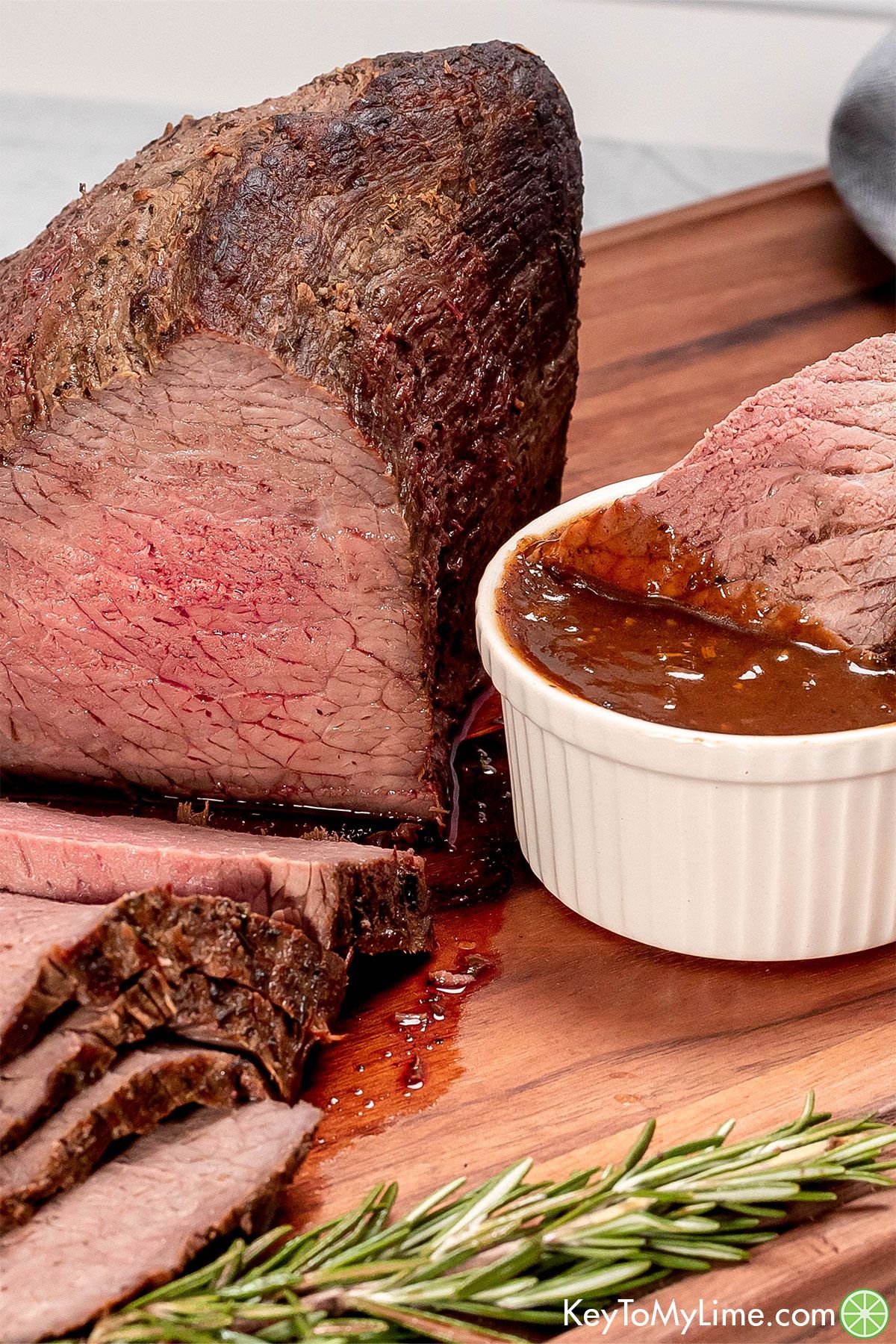 A close up image of a slice of juicy beef roast dipped in a homemade gravy.